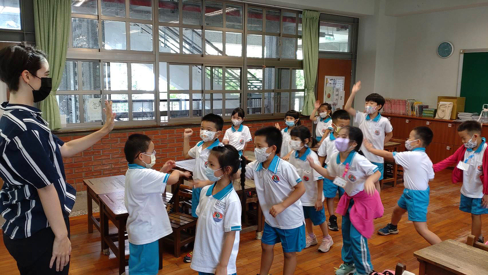 圖為外籍教師Selby(左),讓學童在遊戲中建立英語表達信心,並培養團隊合作能力