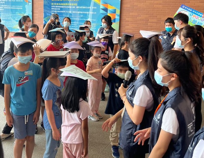 圖為亞大「Sunshine親善志工社」的姐姐們,教小朋友們挑戰「頂書行走」,學習自信走路